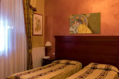 a hotel room with two beds and a picture on the wall at Hotel Joli in Palermo
