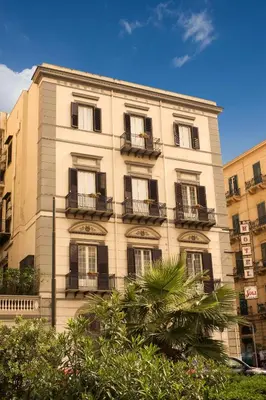 a tall building with balconies on the side of it at Hotel Joli in Palermo