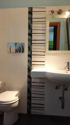 a bathroom with a toilet and a sink and a mirror at Villetta Isola in Isola delle Femmine
