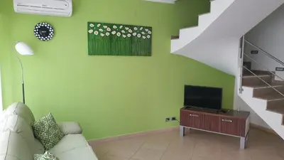 a living room with a couch and a television at Villetta Isola in Isola delle Femmine