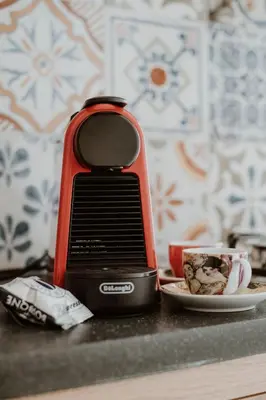 a red phone sitting on a counter next to a plate of food at Casa Vacanze Galati in Palermo