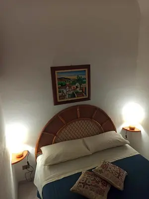 a bedroom with a bed with two pillows on it at CASETTA PONENTE in Isola delle Femmine