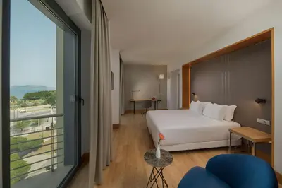 a hotel room with a bed and a large window at NH Palermo in Palermo