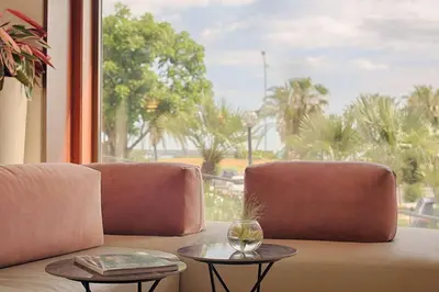 a living room with a couch and two tables at NH Palermo in Palermo