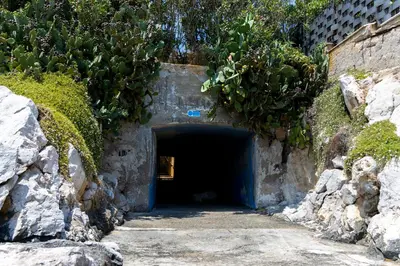 a dark tunnel with a door in a stone wall at Appartamento Ashur Mondello in Palermo