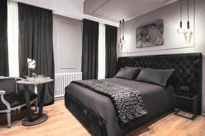 a bedroom with a black bed and a table at Residenze Chamur- Grattacielo in Palermo