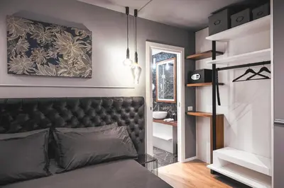a bathroom with a tub and a bed and a television at Residenze Chamur- Grattacielo in Palermo