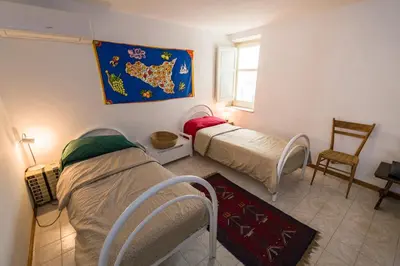 a bedroom with two beds and a map on the wall at APPALERMO la tua casa ideale per visitare la città in Palermo