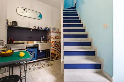 a staircase leading up to a kitchen with blue walls at APPALERMO la tua casa ideale per visitare la città in Palermo