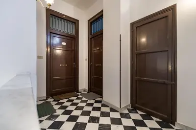 a hallway with two doors and a checkered floor at APPALERMO la tua casa ideale per visitare la città in Palermo