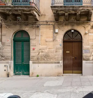 two green doors on the side of a building at APPALERMO la tua casa ideale per visitare la città in Palermo