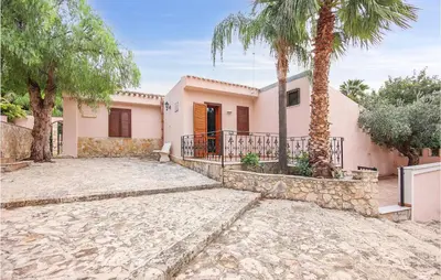 a house with palm trees in front of it at Pietro 4 in San Vito lo Capo