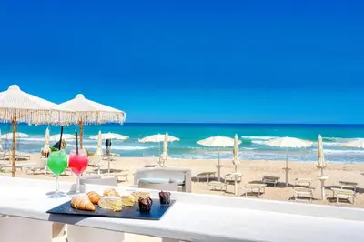 a table with a tray of pastries on the beach at Hotel La Battigia in Alcamo Marina