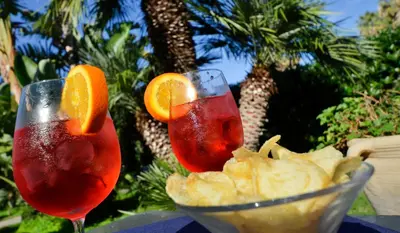 two drinks in glasses next to a bowl of chips at Hotel Villa d'Amato in Palermo