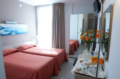 a hotel room with two beds and a mirror at Hotel Villa d'Amato in Palermo