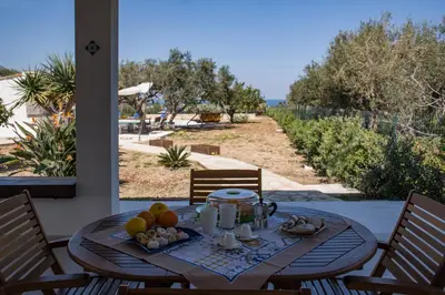 a table with fruit on it on a patio with a view at Scialari Country House in Castellammare del Golfo