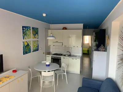 a small kitchen with a table and chairs in a room at La Casetta Blu al Mulino in San Vito lo Capo