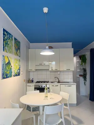 a kitchen with a table and chairs and a blue ceiling at La Casetta Blu al Mulino in San Vito lo Capo