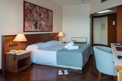 a hotel room with a bed and a desk and a chair at Splendid Hotel La Torre in Mondello
