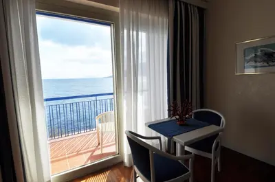 a room with a table and a view of the ocean at Splendid Hotel La Torre in Mondello