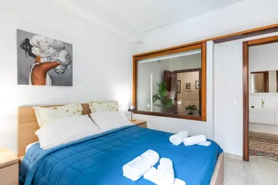 a bedroom with a blue bed with towels on it at GuestHost - Teatro Politeama and Teatro Massimo Cozy Apartment in Palermo