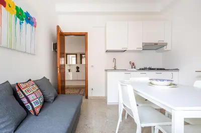 a kitchen and a living room with a couch and a table at GuestHost - Teatro Politeama and Teatro Massimo Cozy Apartment in Palermo