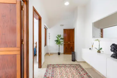 a hallway with a door and a rug at GuestHost - Teatro Politeama and Teatro Massimo Cozy Apartment in Palermo