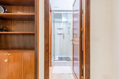 a bathroom with a glass door leading to a shower at GuestHost - Teatro Politeama and Teatro Massimo Cozy Apartment in Palermo