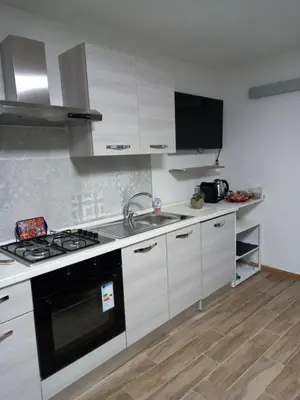 a kitchen with white cabinets and a sink and a stove at Casa dei Tre Re in Palermo