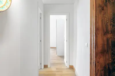 a hallway with white walls and a wooden floor at Kalbita home in Palermo