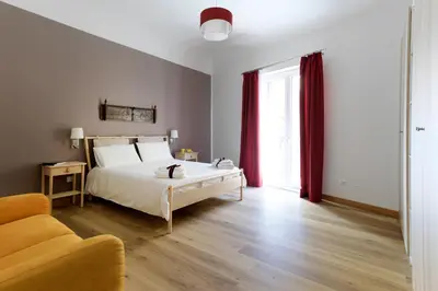 a bedroom with a white bed and red curtains at Kalbita home in Palermo