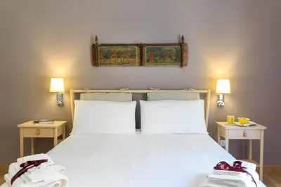 a bedroom with a large white bed with two tables at Kalbita home in Palermo
