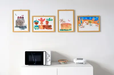 a shelf with a microwave and four pictures on a wall at Kalbita home in Palermo