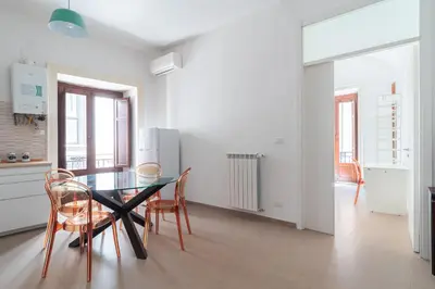 a kitchen with a table and chairs in a room at Quattro Canti by DomuSicily in Palermo