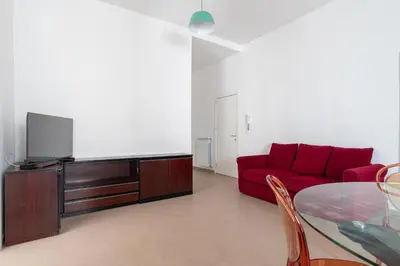 a living room with a red couch and a glass table at Quattro Canti by DomuSicily in Palermo
