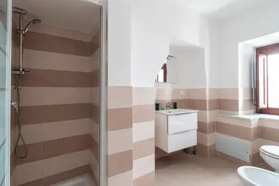 a bathroom with a shower and a toilet and a sink at Quattro Canti by DomuSicily in Palermo