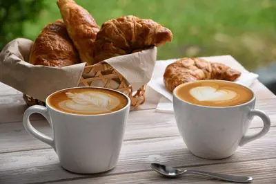 two cups of coffee and a basket of croissants at Exclusive in Palermo