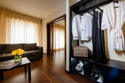 a living room with a couch and a shelf with clothes at Astoria Palace Hotel in Palermo