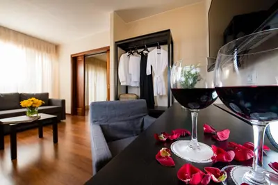 two glasses of wine on a table in a living room at Astoria Palace Hotel in Palermo