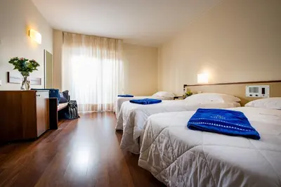 a hotel room with three beds with blue towels on them at Astoria Palace Hotel in Palermo