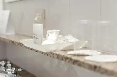 a bathroom counter with a sink and toiletries on it at Astoria Palace Hotel in Palermo