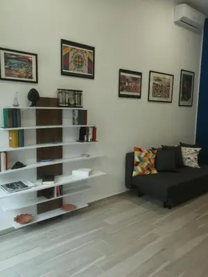 a living room with a couch and a book shelf at atocà1 casa vacanze - vedi anche atocà2 in Palermo