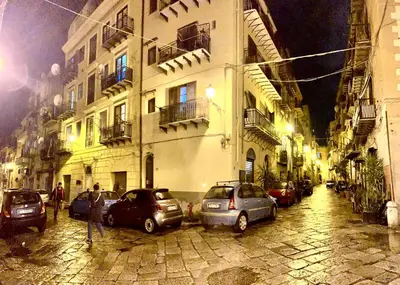 a city street with cars parked in front of buildings at Loft Aragonese in Palermo
