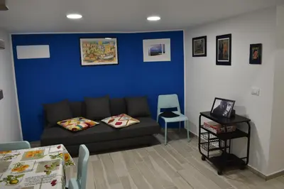 a living room with a couch and a blue wall at atocà2 confortevole loft- vedi anche atocà1 in Palermo