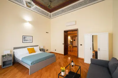 a bedroom with a bed and a couch at Open Sicily Residence - Central Apartments Near Quattro Canti in Palermo
