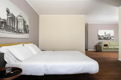 a bedroom with a large white bed and a couch at Suite al centro di Palermo con terrazza privata in Palermo