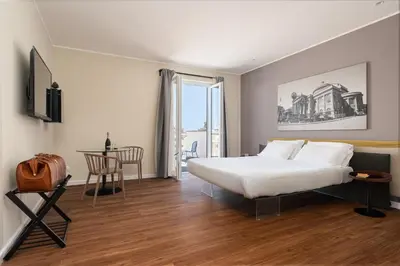 a hotel room with a bed and a table and a window at Suite al centro di Palermo con terrazza privata in Palermo