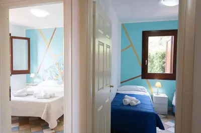 a bedroom with blue walls and a bed and a window at Villa Morici con ampio giardino in San Vito lo Capo