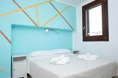 a blue room with a bed with towels on it at Villa Morici con ampio giardino in San Vito lo Capo