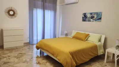 a bedroom with a bed with a yellow blanket at Amunì rooms and suite LT in Palermo